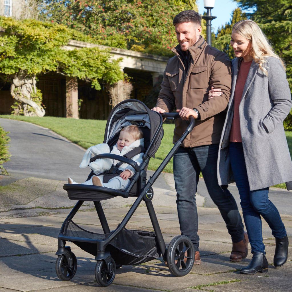 happy parents pushing baby in pram